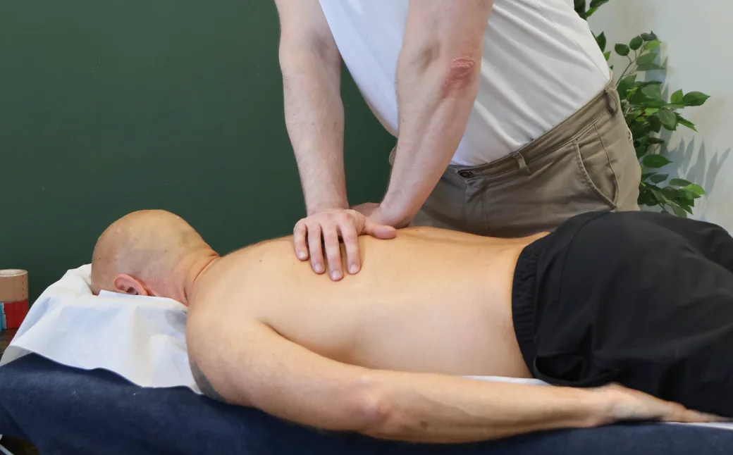 Hands on soft tissue treatment to the back on the treatment plinth